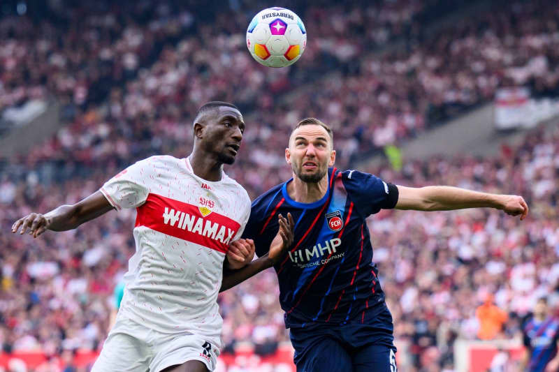 Stuttgart's Serhou Guirassy (L) and Heidenheim's Benedikt Gimber battle for the ball during the German Bundesliga soccer match between VfB Stuttgart and 1. FC Heidenheim at MHPArena. Tom Weller/dpa