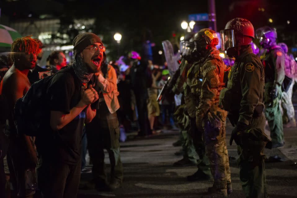 Un manifestante gritando a los oficiales federales tras usar gases lacrimógenos y armas “menos letales” para dispersar una protesta ocurrida el jueves en Portland, Oregón (Nathan Howard/Getty Images)