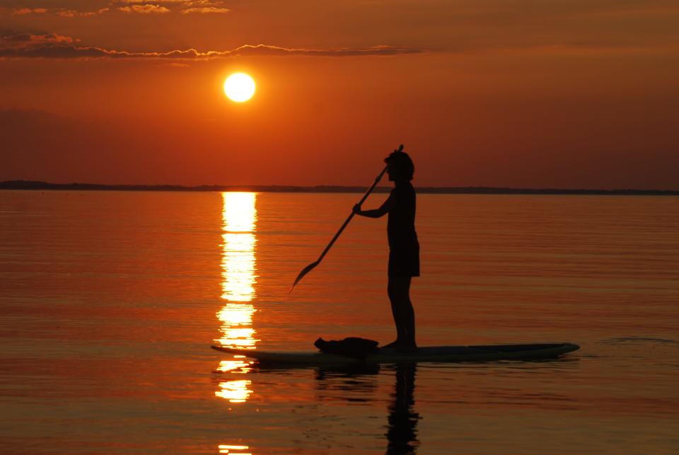 A paddleboarder takes in the sunset. Visitors of Delaware beaches can rent paddleboards from Delmarva Board Sports and other locations. (Photo provided by Delmarva Board Sport Adventures)