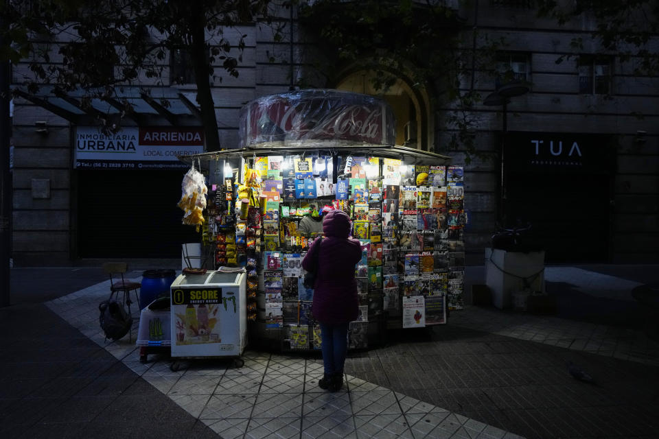 A customer wearing a puffer jacket stands in front of a kiosk, in Santiago, Chile, Friday, May 17, 2024. Bitter cold is gripping Chile, a country that doesn't usually experience frost and wind chills this time of year. (AP Photo/Esteban Felix)