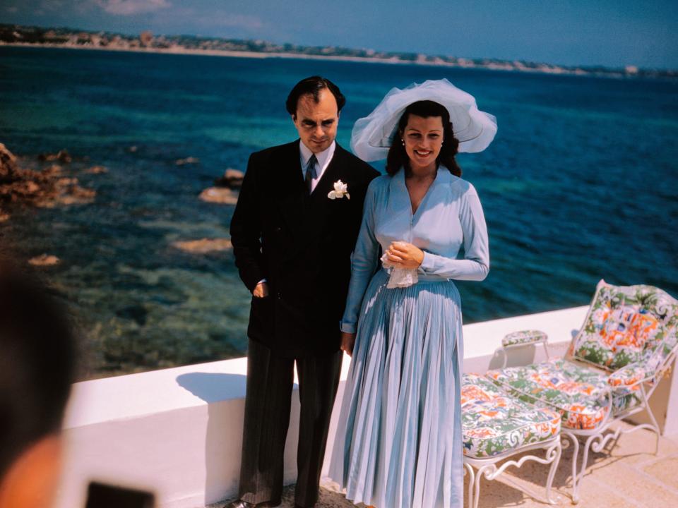Rita Hayworth in a blue dress and Prince Aly Khan on their wedding day.