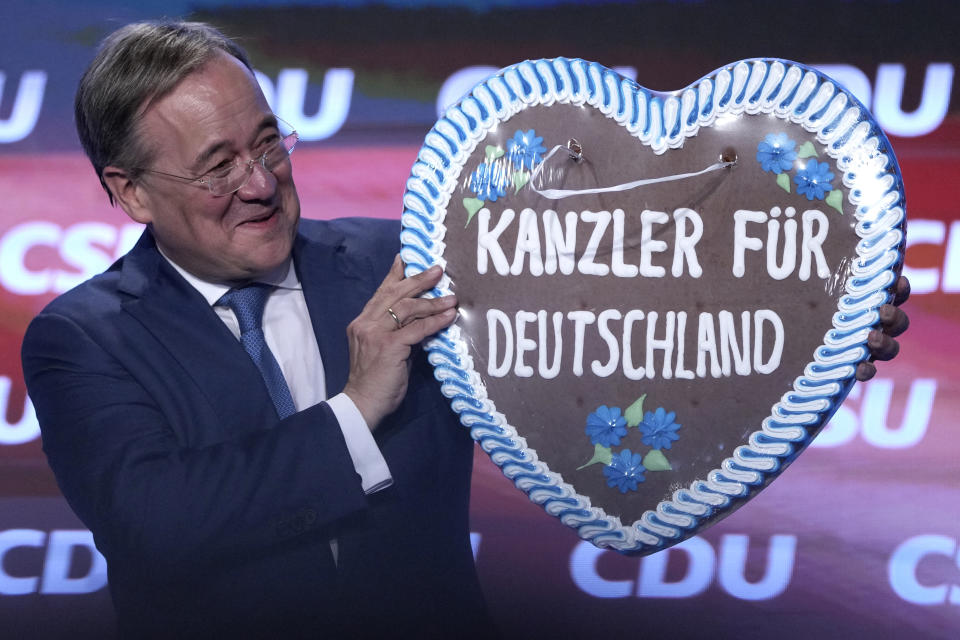 FILE - In this Friday, Sept. 24, 2021 file photo, Christian Democrats chancellor candidate Armin Laschet lifts a gingerbread heart reading "Chancellor for Germany" during a election campaign event in Munich, Germany. Germany’s closely fought election on Sunday will set the direction of the European Union’s most populous country after 16 years under Angela Merkel, whose party is scrambling to avoid defeat by its center-left rivals after a rollercoaster campaign. (AP Photo/Matthias Schrader, File)