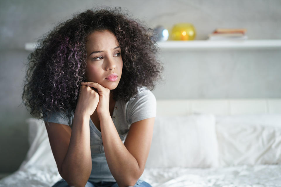 woman sitting on her bed