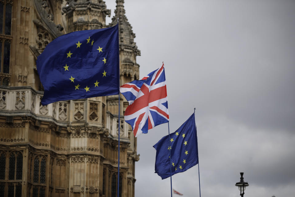 European flags and a British Union flag placed by anti-Brexit remain in the European Union supporters are blown by the wind across the street from the Houses of Parliament, not pictured, backdropped by Westminster Abbey in London, Monday, March 18, 2019. British Prime Minister Theresa May was making a last-minute push Monday to win support for her European Union divorce deal, warning opponents that failure to approve it would mean a long — and possibly indefinite — delay to Brexit. Parliament has rejected the agreement twice, but May aims to try a third time this week if she can persuade enough lawmakers to change their minds. (AP Photo/Matt Dunham)