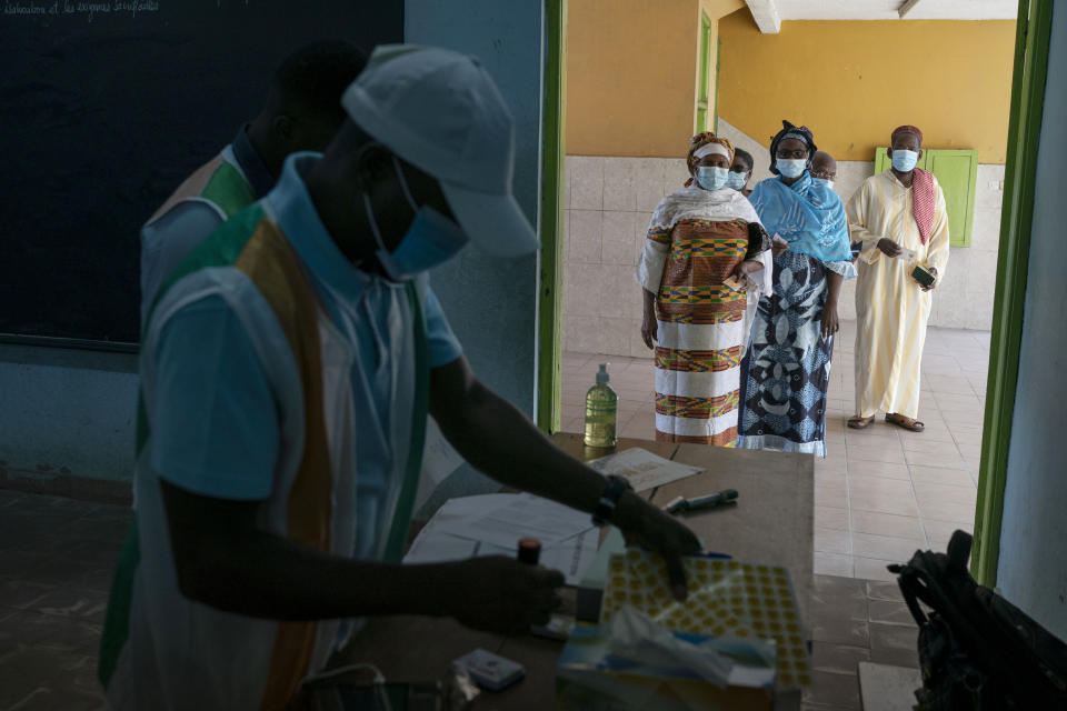 People wait in line to vote in presidential election in Abidjan, Ivory Coast, Saturday, Oct. 31, 2020. Tens of thousands of security forces deployed across Ivory Coast on Saturday as the leading opposition parties boycotted the election, calling President Alassane Ouattara's bid for a third term illegal. (AP Photo/Leo Correa)