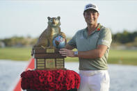 Viktor Hovland, of Norway, holds the championship trophy after the final round of the Hero World Challenge PGA Tour at the Albany Golf Club, in New Providence, Bahamas, Sunday, Dec. 5, 2021.(AP Photo/Fernando Llano)