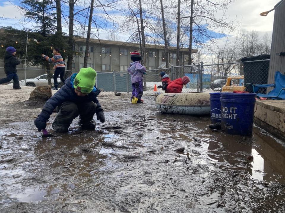 Preschoolers play in the snowmelt at Hillcrest Children's Center in Anchorage on April 18, 2024. (Photo by Claire Stremple/Alaska Beacon)