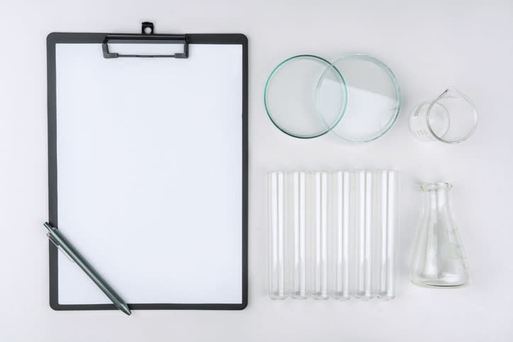A bird's eye view of various lab glassware and a clipboard.