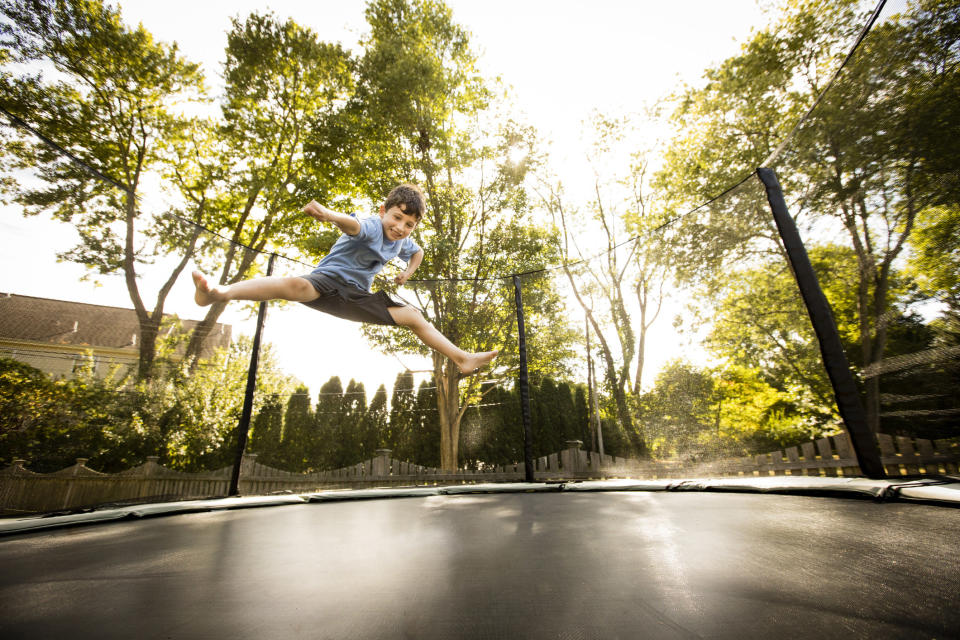 Young boy jumping on large trampoline