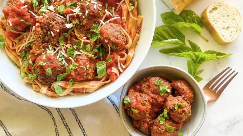 Meatballs with pasta in bowl and serving dish