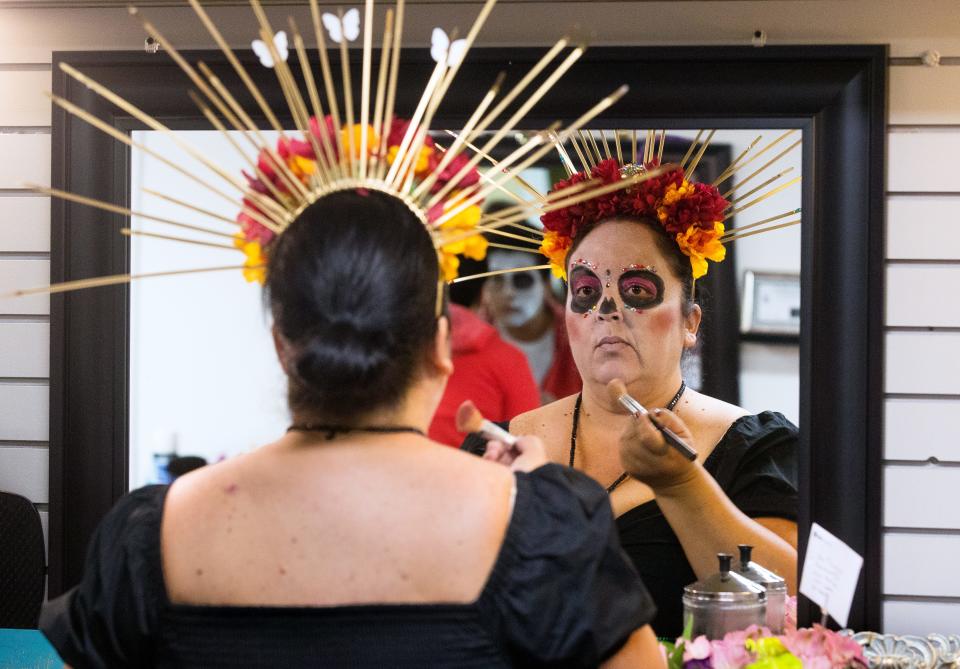 Elisabeth Bandy applies makeup as she prepares to help host a showing of the Disney/Pixar film "Coco" at the Route 66 Drive In Theater Thursday, Oct. 15, 2020. Bandy and other members of the Hispanic Women of Springfield hosted the event as part of Hispanic Heritage Month that included pan dulce, or sweet bread, hot chocolate and up displays of "altares de muertos," Day of the Dead altars that are traditional in Mexico for All Saints Day on Nov. 1 and All Souls Day Nov. 2. The movie, about a 12-year-old boy who accidentally crosses over to the land of the dead, sparked widespread interest in the traditional Mexican observance.