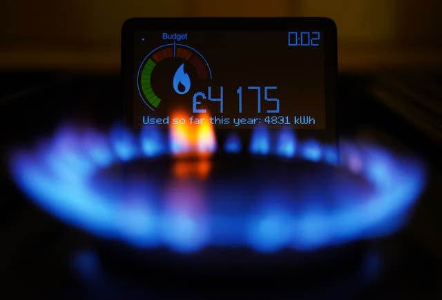 A lit gas ring in front of a energy usage smart meter 