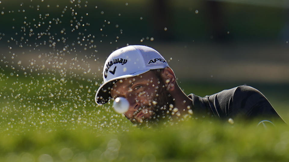 Jon Rahm, of Spain, hits out of the bunker on the 14th hole during the first round of the BMW Championship golf tournament at Wilmington Country Club, Thursday, Aug. 18, 2022, in Wilmington, Del. (AP Photo/Julio Cortez)