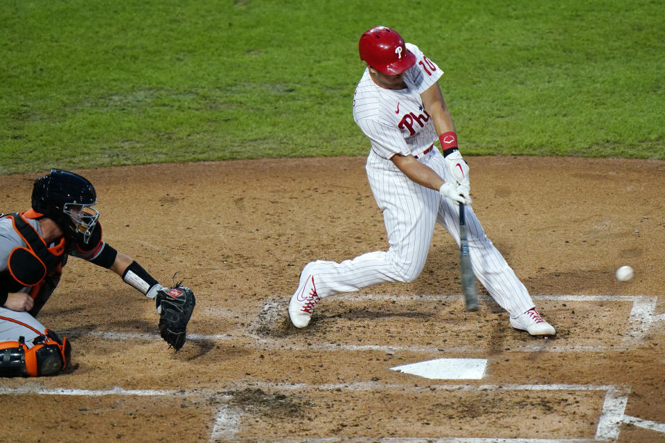 Philadelphia Phillies' J.T. Realmuto hits an RBI-single off Baltimore Orioles pitcher Wade LeBlanc during the third inning of a baseball game, Wednesday, Aug. 12, 2020, in Philadelphia. (AP Photo/Matt Slocum)