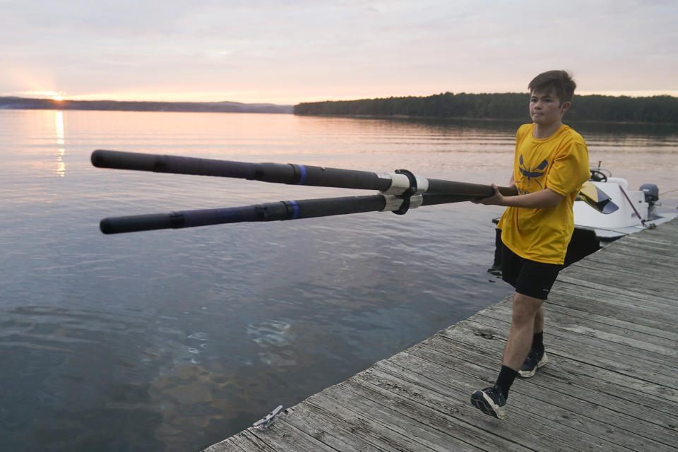 Callum Bradford carries a set of paddles off a boat following a rowing club practice at Jordan Lake, Friday, Oct. 6, 2023, in Apex, N.C. Bradford, a transgender teen from Chapel Hill needed mental health care after overdosing on prescription drugs. He was about to be transferred to another hospital due to a significant bed shortage. A North Carolina hospital network is referring transgender psychiatric patients to treatment facilities that do not align with their gender identities. Though UNC Hospitals policy discourages the practice, administrators say a massive bed shortage is forcing them to make tough decisions. (AP Photo/Erik Verduzco)