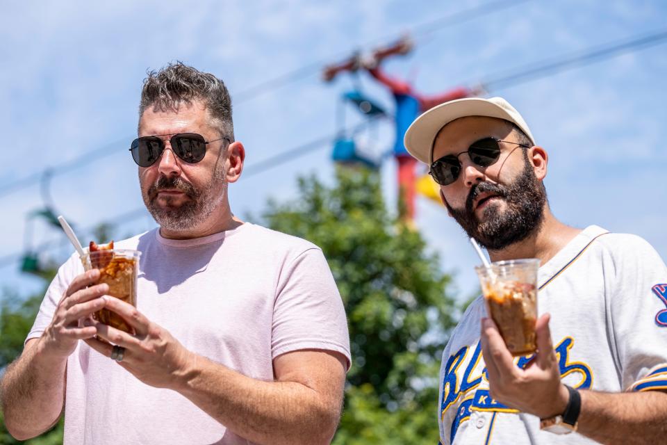 Professional chefs Alex Carter, owner of Black Cat Ice Cream, and Rateb Aburas, executive chef of Mulberry Street Tavern and the Surety Hotel Des Moines, try the Pork Picnic in a Cup from Iowa Pork Producers at the Iowa State Fair.