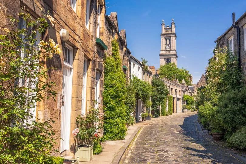 Warm sunny July weather in Edinburgh, with flowers growing outside the mews houses on Circus Lane in Stockbridge, Edinburgh.