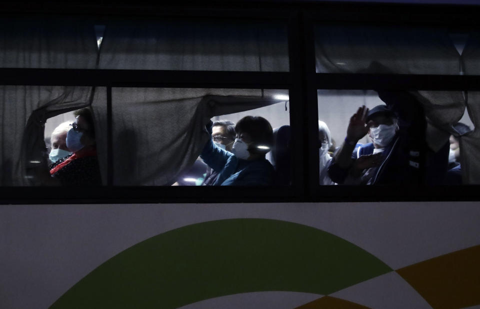 A bus carrying Australian passengers disembarked from the quarantined Diamond Princess cruise ship leaves a port Wednesday, Feb. 19, 2020, in Yokohama, near Tokyo. About 500 passengers left the cruise ship Diamond Princess on Wednesday at the end of a much-criticized two-week quarantine aboard the vessel, docked in Japan, that failed to stop the spread of the new virus among passengers and crew. (AP Photo/Jae C. Hong)