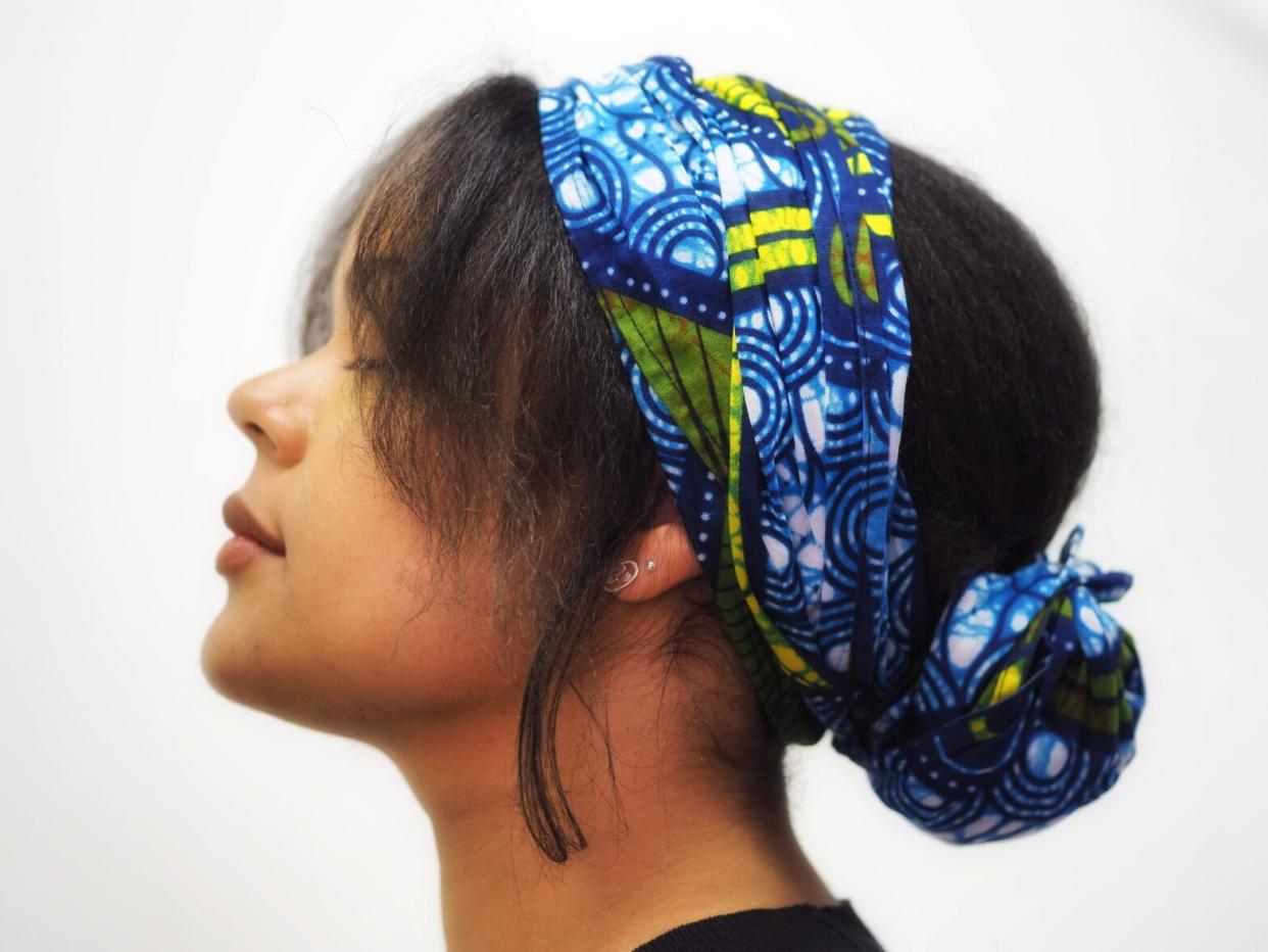 bandana hairstyles that are black hair friendly. Pictured: black girl with bandana hairstyle with bun.