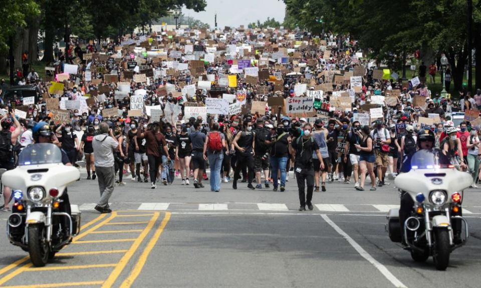 Demonstrators hold signs as they walk down Capitol Hill during a protest against racial inequality in the aftermath of the death in Minneapolis police custody of George Floyd, in Washington.