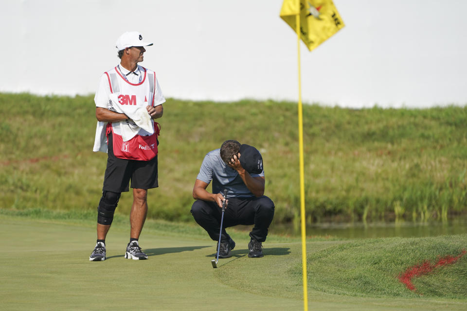 Cameron Champ, right, takes a moment with his caddie Chad Reynolds, before making his final shot and winning the 3M Open golf tournament in Blaine, Minn., Sunday, July 25, 2021. (AP Photo/Craig Lassig)