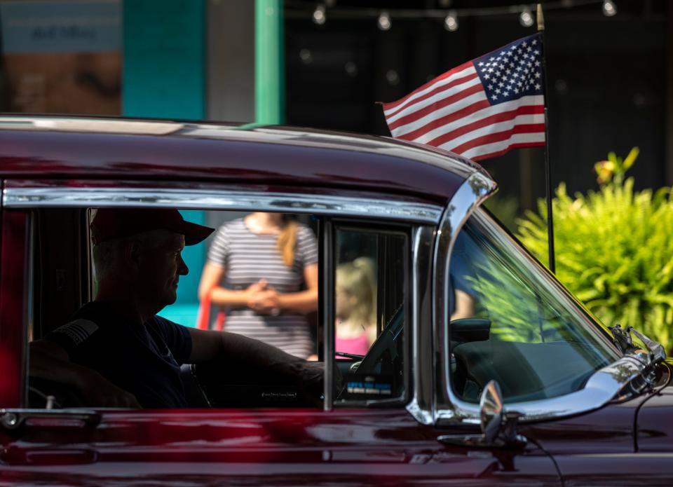 The driver of a Cadillac is silhouetted in the window of his car while participating in the Jeffersonville, Indiana Freedom Parade. July 3, 2021