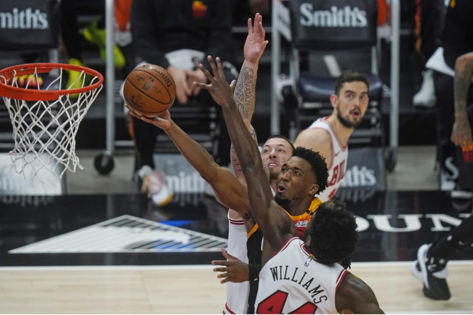 Utah Jazz guard Donovan Mitchell, center, goes to the basket as Chicago Bulls' Daniel Theis, rear, and Patrick Williams (44) defend in the second half during an NBA basketball game Friday, April 2, 2021, in Salt Lake City. (AP Photo/Rick Bowmer)