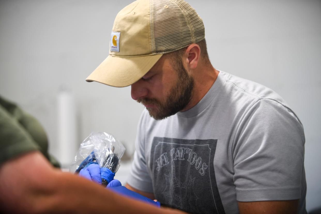 Jonah Huff works on a piece during the Tattoo Garden's 