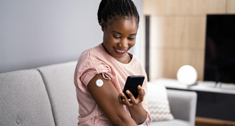 Woman Testing Glucose Level With Continuous Glucose Monitor
Woman Testing Glucose Level With Continuous Glucose Monitor On Mobile Phone. (Getty Images)