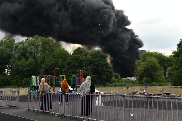 People watch on as smoke billows from a severe blaze on an industrial estate in Birmingham 