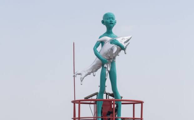 The 7.8-metre sculpture, Boy Holding A Shark, is part of the Vancouver Biennale, a public art exhibition held every two years. (Vancouver Biennale - image credit)