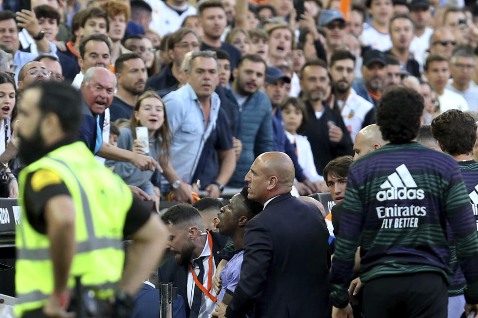 Real Madrid's Vinicius Junior, lower centre, reacts towards Valencia fans after being sent off during a Spanish La Liga soccer match between Valencia and Real Madrid, at the Mestalla stadium in Valencia, Spain, Sunday, May 21, 2023. The game was temporarily stopped when Vinicius said a fan had insulted him from the stands. He was later sent off after clashing with Valencia players. (AP Photo/Alberto Saiz)