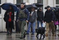 A K-9 team walks past people waiting to enter Brooklyn federal court, Tuesday, Nov. 13, 2018, in New York. Opening statements at the trial of the notorious Mexican drug lord Joaquin "El Chapo" Guzman are to begin Tuesday morning under tight security. The evidence will include the testimony of more than a dozen cooperating witnesses who prosecutors say are risking retribution by taking the stand. (AP Photo/Mark Lennihan)