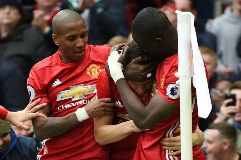 Manchester United's Ashley Young (L) and Eric Bailly (R) congratulate Ander Herrera after he scored their second goal against Chelsea