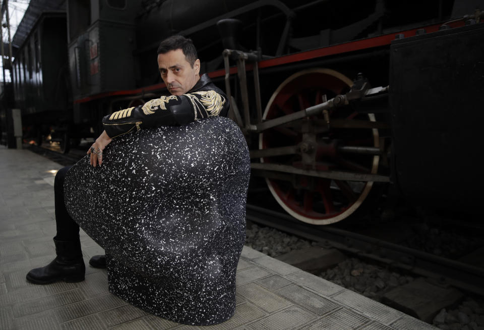 In this picture taken on Saturday, April 13, 2019, Italian designer Fabio Novembre poses sitting on his 'Jolly Roger' chair, made with upcycled plastics, at the National Museum of Science and Technology, during the "RO Plastic - Master's Pieces" exhibition', on the sidelines of the Salone del Mobile International Furniture Fair week, in Milan, Italy. Scientists and environmental activists have been long raised the alarm on plastic pollution. Now, the high-end design world is getting in on the growing global effort to tackle plastic pollution -- by upcycling discarded objects into desirable one-off design pieces. (AP Photo/Luca Bruno)