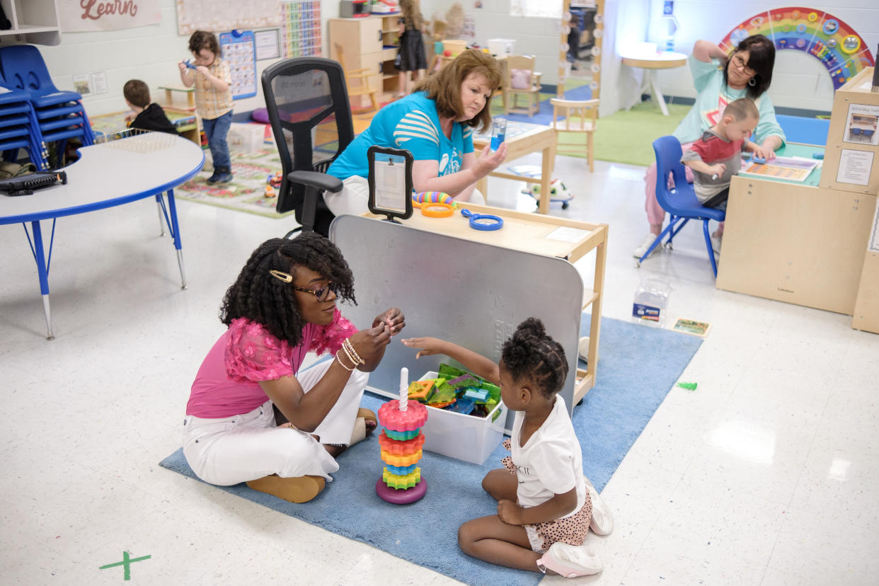 Michaela Frederick, a pre-K teacher, plays a stacking game with a student in Sharon, Tenn., June 17, 2024. (Aaron Hardin/The New York Times)