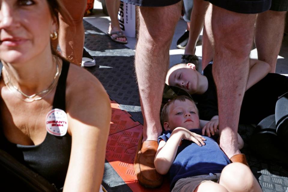 Children lay on the ground while listening to Florida Governor Ron DeSantis participate in a "Fair-Side Chat" on Aug. 12.<span class="copyright">Chip Somodevilla—Getty Images</span>