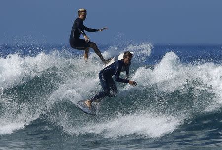 Surfers come close to colliding as they gather off the shore of Solana Beach, California to catch waves being generated out in the Pacific Ocean by Hurricane Marie August 27, 2014. REUTERS/Mike Blake