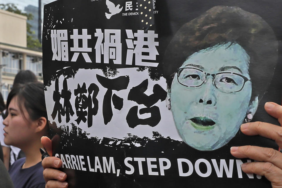 In this Monday, June 17, 2019, photo, a protester holds a placard baring an image of Hong Kong Chief Executive Carrie Lam as they gather near the Legislative Council to continue protest against the unpopular extradition bill in Hong Kong. The various pro-democracy groups that helped drive and organize the protests are pushing for Lam’s resignation and the permanent scrapping of what they call the “evil” extradition bill. (AP Photo/Kin Cheung)