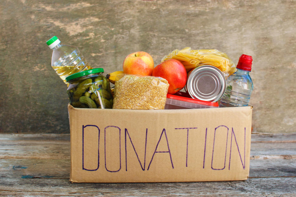 Donation box with food on old wooden background