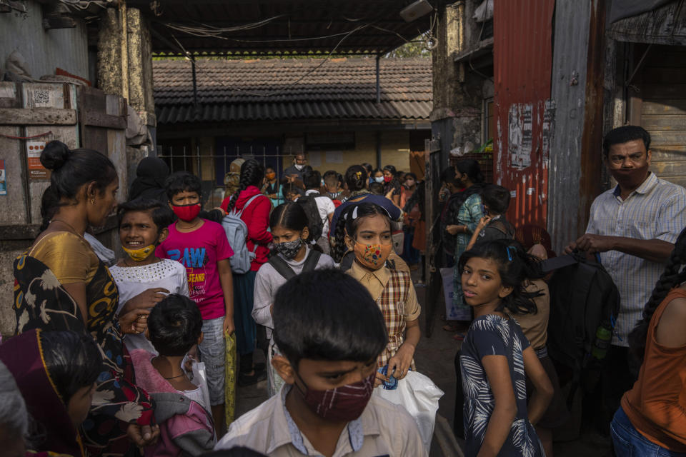 Students wearing masks leave school after attending classes in Dharavi, one of Asia's largest slums, in Mumbai, India, Monday, Jan. 24, 2022. Mumbai schools reopened Monday, after a closure due to rising COVID-19 cases. (AP Photo/Rafiq Maqbool)