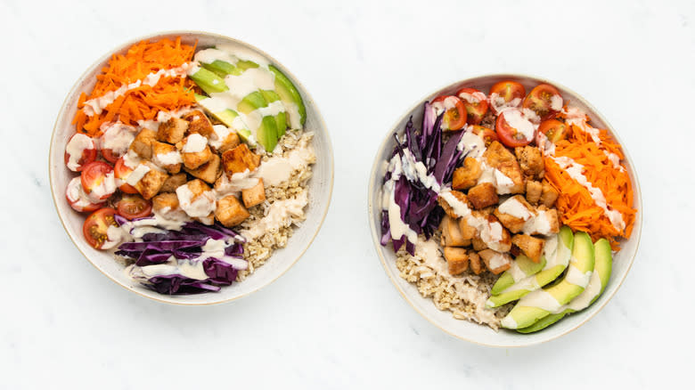 Two tofu grain bowls with dressing
