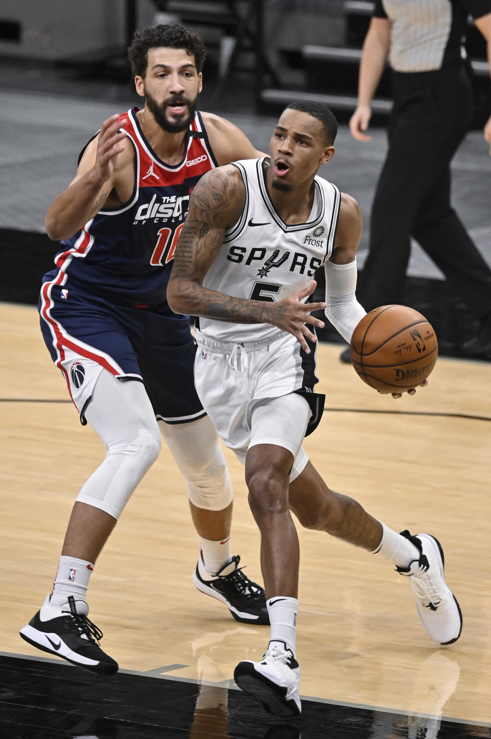 San Antonio Spurs' Dejounte Murray, right, drives around Washington Wizards' Anthony Gill during the first half of an NBA basketball game, Sunday, Jan. 24, 2021, in San Antonio. (AP Photo/Darren Abate)