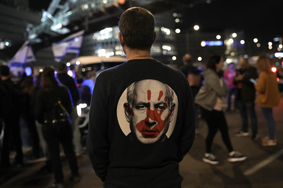 FILE - A protester wears a shirt depicting Israeli Prime Minister Benjamin Netanyahu attempt during a demonstration to demand the release of the hostages taken by Hamas militants into the Gaza Strip during the Oct. 7th attack, in Tel Aviv, Israel, Saturday Jan. 20, 2024. After the Oct. 7 attack by Hamas, Israelis put aside their differences and rallied behind the war effort in Gaza. But as the war grinds on, the mood of the Israeli public is shifting and old divisions are reemerging. The catalyst is a rift over the polarizing leadership of Netanyahu and a growing frustration with his management of the war. (AP Photo/Leo Correae, File)