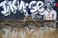 A boy steps across a flooded area next to an informational mural with words in Swahili advising people to protect themselves from the coronavirus and get vaccinated, in the low-income Kibera neighborhood of Nairobi, Kenya, Saturday, June 12, 2021. Africa's 1.3 billion people account for 18% of the world’s population. But the continent has received only 2% of all vaccine doses administered globally. (AP Photo/Brian Inganga)