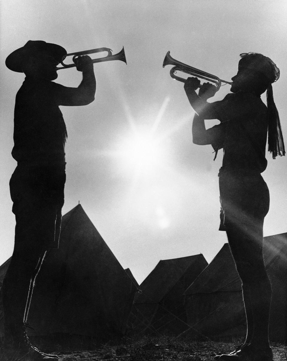 FILE - In this Aug. 9, 1967, file photo, two boy scout members play the bugle at the 12th World Boy Scout Jamboree at Farragut State Park in Idaho. The Boy Scouts of America has filed for bankruptcy protection as it faces a barrage of new sex-abuse lawsuits. The filing Tuesday, Feb. 18, 2020, in Wilmington, Del., is an attempt to work out a potentially mammoth compensation plan for abuse victims that will allow the 110-year-old organization to carry on. (AP Photo/Jack Kanthal, File)