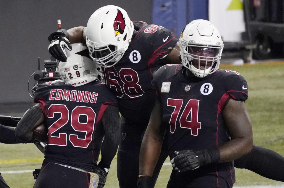 Arizona Cardinals running back Chase Edmonds (29) celebrates with Kelvin Beachum (68) and D.J. Humphries (74) after Edmonds scored a touchdown against the Seattle Seahawks during the second half of an NFL football game, Thursday, Nov. 19, 2020, in Seattle. (AP Photo/Elaine Thompson)