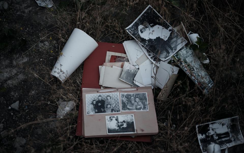 An old abandoned photo album of a family that fled the war lies strewn on the ground