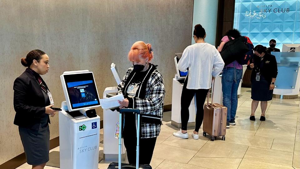 Travelers check-in at five self-service kiosks in the lower Sky Club lobby…