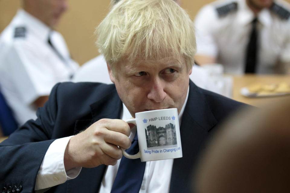 Britain's Prime Minister Boris Johnson takes a drink from a prison mug as he talks with prison staff during a visit to HM Prison Leeds, in Leeds, Britain August 13, 2019.  Jon Super/Pool via REUTERS